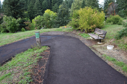 Paved Overlook Trail with directional signage and bench at switchback – one of many switchbacks